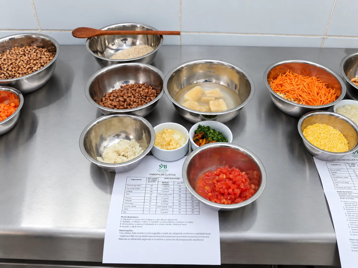 Ingredientes vegetais organizados em recipientes sobre bancada de cozinha.