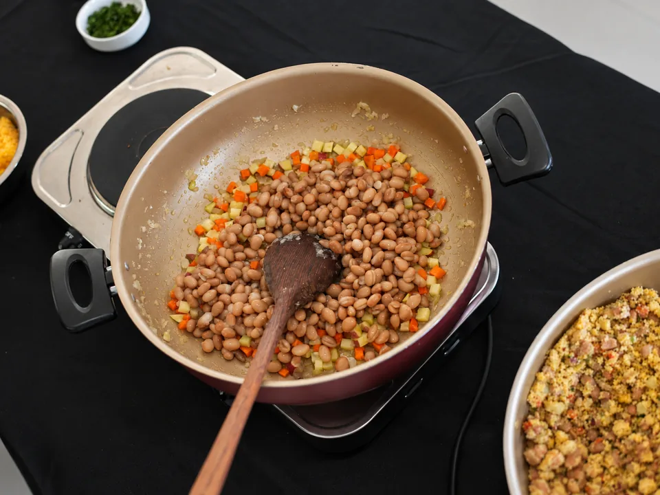 Panela com preparo de feijões e legumes durante atividade culinária do PROVE.